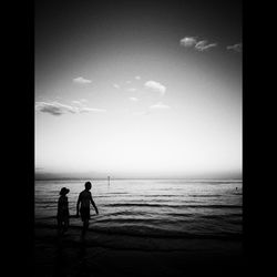 Silhouette people on beach against sky