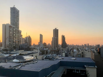 Modern buildings in beirut city against clear sky during sunset