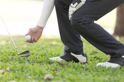 Low section of man playing golf on grassy field