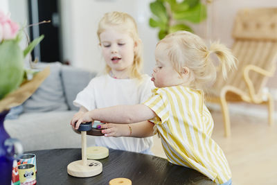 Sisters playing with stacking tower