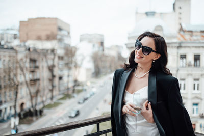 Young woman wearing sunglasses standing in city