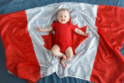 Baby girl lying on canadian flag 