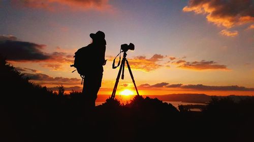 Silhouette photographer against scenic sky