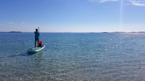 Rear view of man on sea against sky