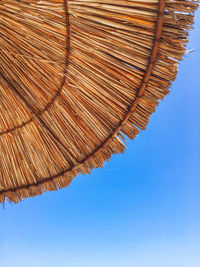 Bottom view of straw beach umbrella on clear blue sky background.  vacation.  kemer, turkey.