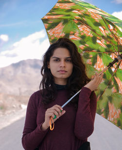 Portrait of beautiful woman standing against wall
