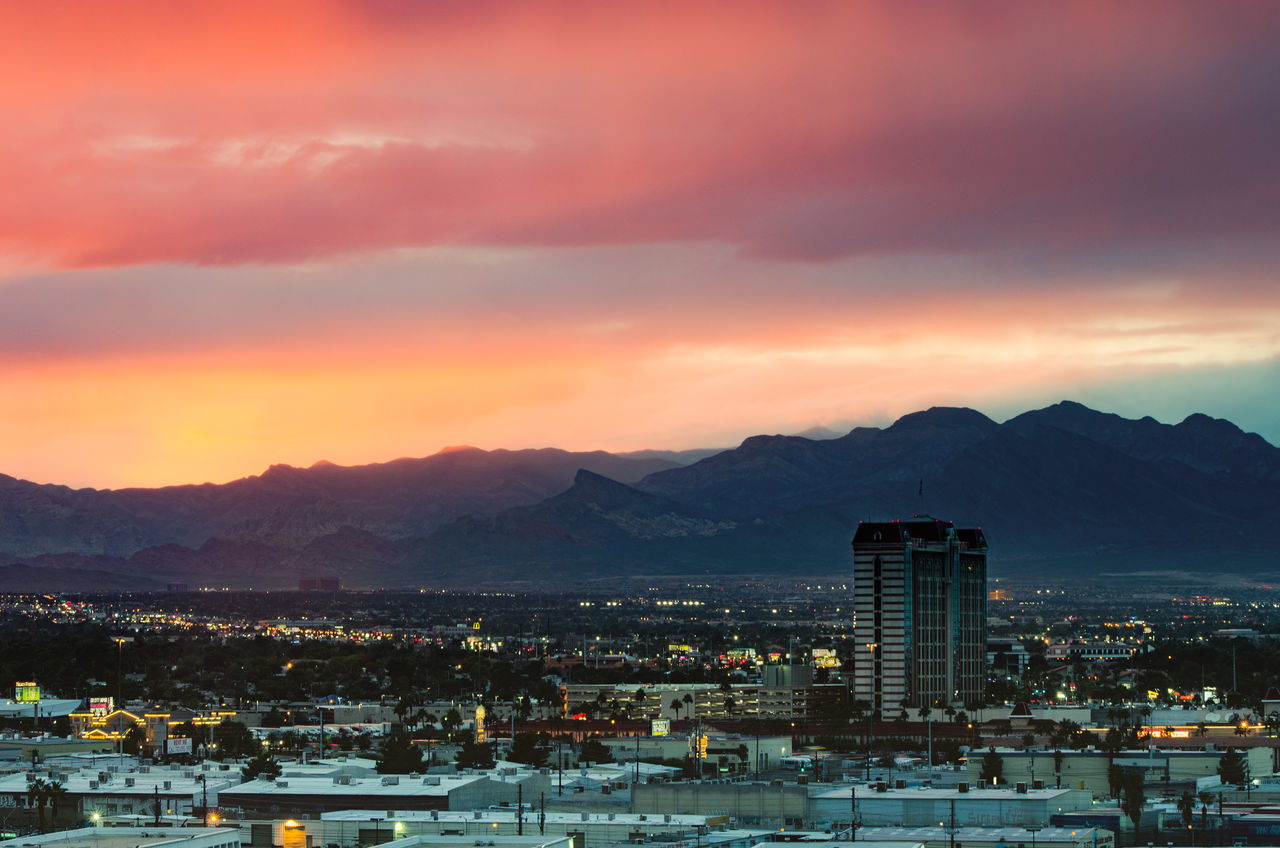 architecture, building exterior, built structure, mountain, sunset, cityscape, sky, no people, city, mountain range, residential building, outdoors, nature, scenics, beauty in nature, sea, illuminated, day