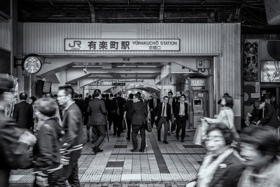 People walking on railroad track in city