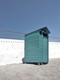 Built structure on beach against clear blue sky