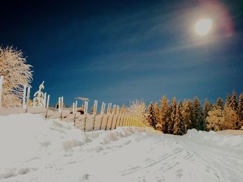 Scenic view of snow covered field against sky