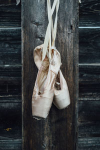 Ballet shoes hanging from wooden wall