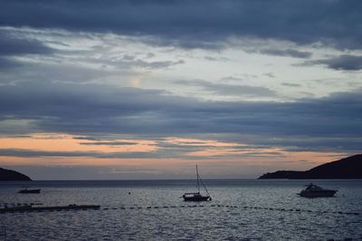 Sailboat sailing on sea against sky during sunset