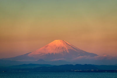 Scenic view of snowcapped mountains against sky during sunrise