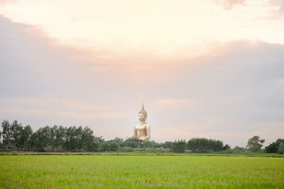 View of grassy field against cloudy sky