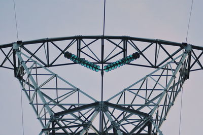 Low angle view of electricity pylon against clear sky