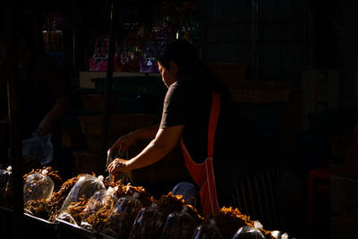 Woman working at market stall at night