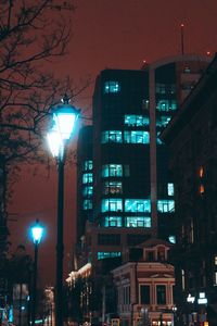 Low angle view of illuminated buildings against sky at night