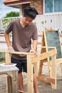 Full length of young man sitting on table
