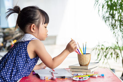 Girl looking away while holding table