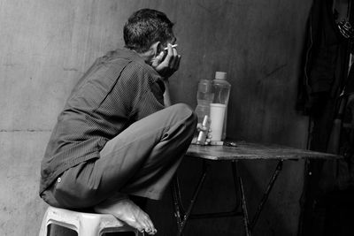 Side view of young man sitting outdoors