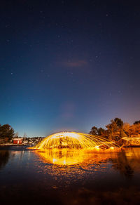 Scenic view of lake against sky at night