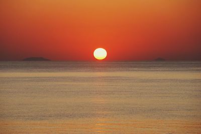 Scenic view of sea against orange sky