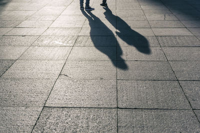 Shadow of people on footpath