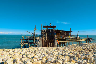 Lifeguard hut on beach against clear blue sky