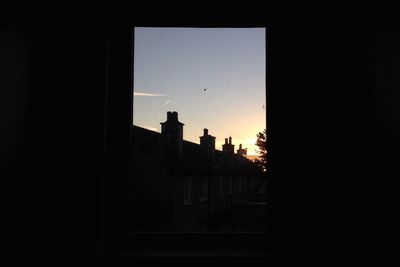 Silhouette built structures at sunset