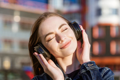 Young energetic cheerful caucasian woman wearing headphones. dressed in a denim