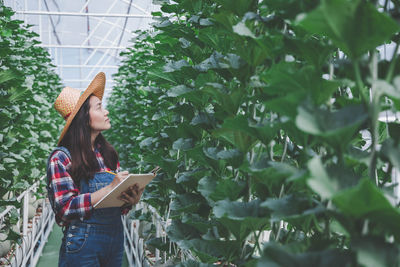 Woman standing by plants