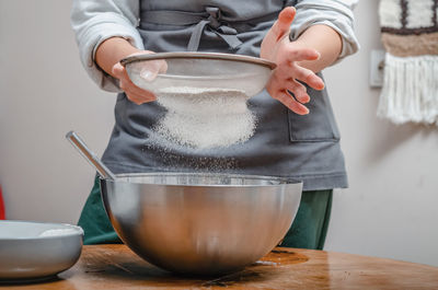 Cook sifts flour through sieve to make dough