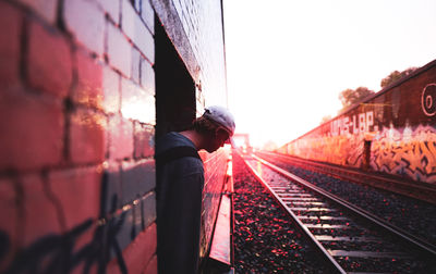 Rear view of man walking on railroad track