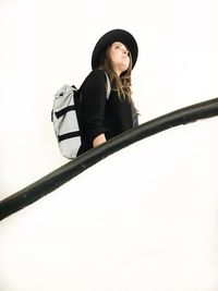 Portrait of young woman standing against white background