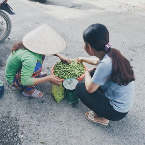 High angle view of female vendor selling food to customer on street