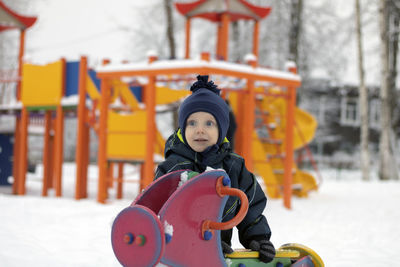 Portrait of boy playing with toy on snow