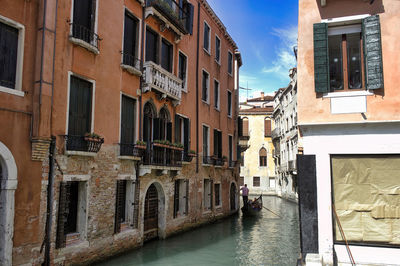 Venice, italy wide view of tourists in gondola in narrow canal with green water, romantic concept