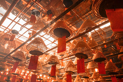 Low angle view of spiral incenses hanging in temple