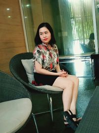 Portrait of young woman sitting on chair