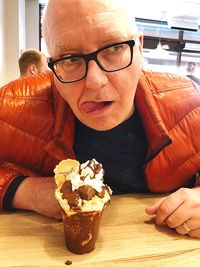 Portrait of man with ice cream on table