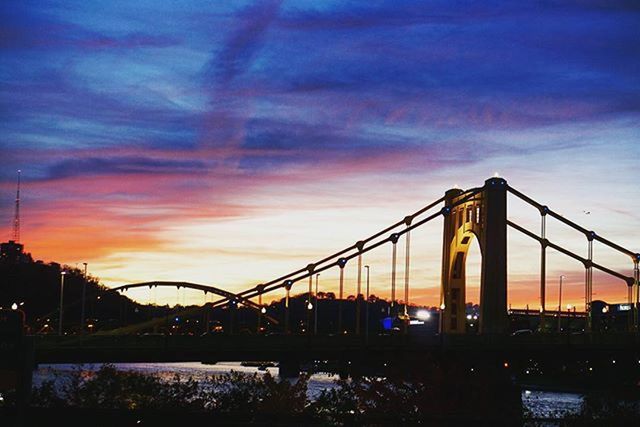 bridge - man made structure, connection, sunset, built structure, architecture, sky, engineering, transportation, suspension bridge, bridge, cloud - sky, silhouette, dusk, water, orange color, low angle view, river, cloud, illuminated, outdoors