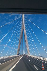 Low angle view of suspension bridge against blue sky