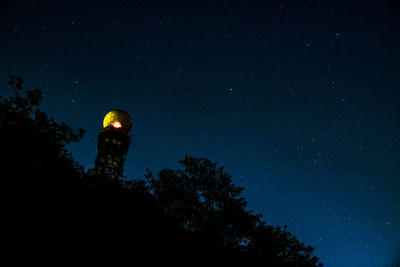 Low angle view of illuminated tower against sky at night