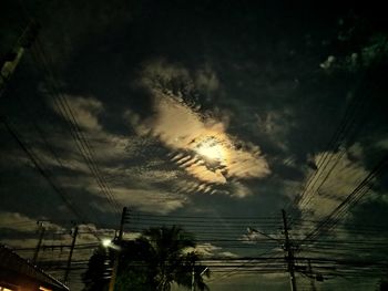 Low angle view of silhouette electricity pylon against sky during sunset