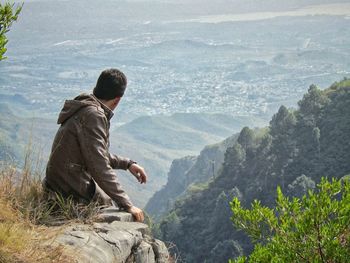 Man on margalla hills looking at mountains