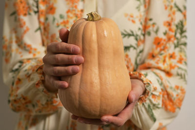 Close-up of baby hand holding pumpkin