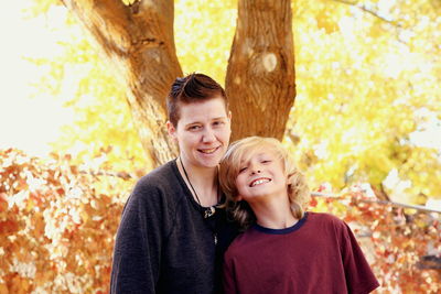 Portrait of happy mother and son in park during autumn