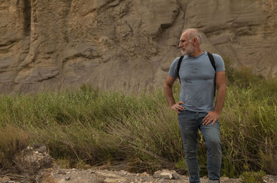 Adult man on tabernas desert in almeria, spain, against grass and rock