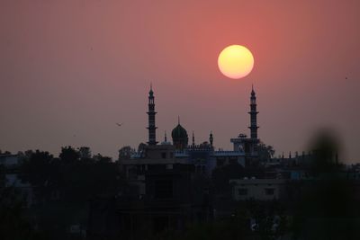 Silhouette of buildings against sky during sunset