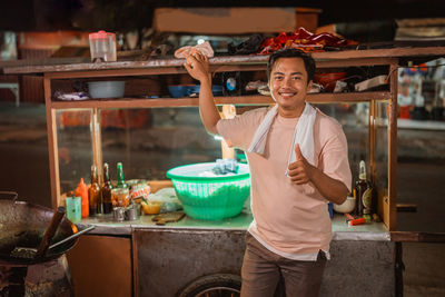 Portrait of smiling young woman preparing food at home